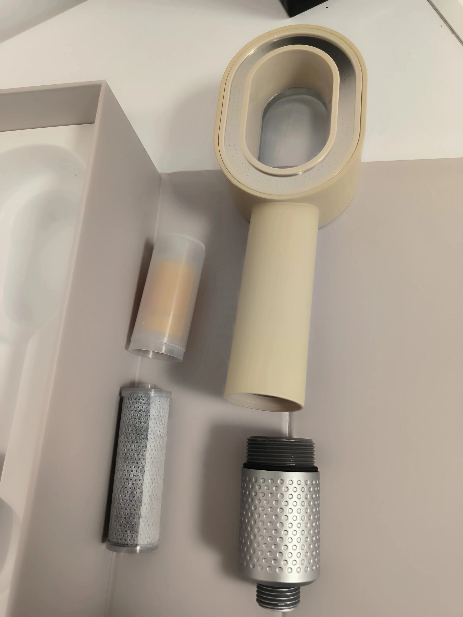 Photo du pommeau beige avec les 2 filtre, un filtre ACF anti chlore et calcaire et un filtre parfumé